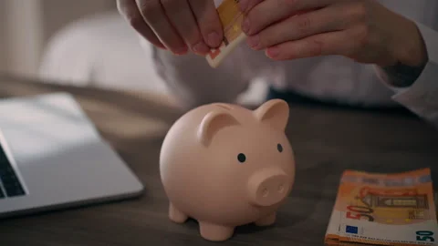 Close up of hands putting 50 euro banknote into piggy bank, symboliz saving.. Stock Footage 337179757