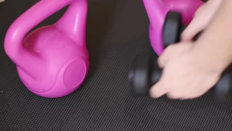 Close up hands putting dumbbells on black fitness zone Stock Footage 237729192