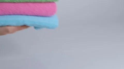 Close-up of hands putting stack of fresh bath towels on the bed sheet. Room Stock Footage 124083428
