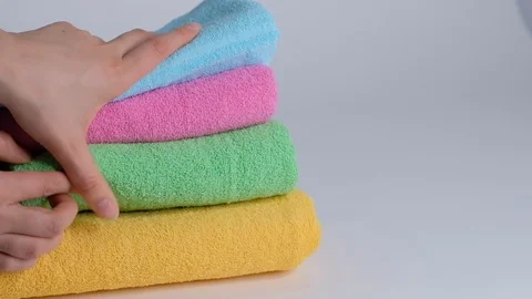 Close-up of hands putting stack of fresh bath towels on the bed sheet. Room Stock Footage 124083522