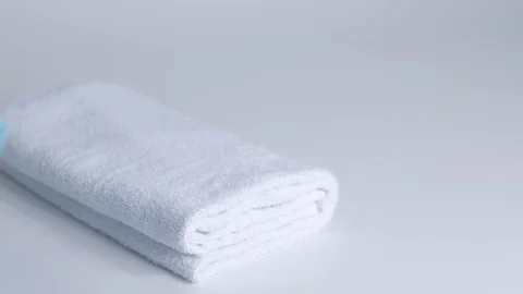 Close-up of hands putting stack of fresh bath towels on the bed sheet. Room Stock Footage 124083563
