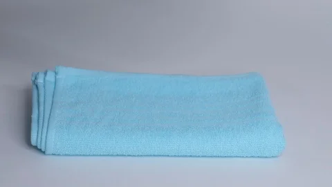 Close-up of hands putting stack of fresh bath towels on the bed sheet. Room Stock Footage 124204907