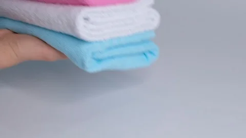 Close-up of hands putting stack of fresh bath towels on the bed sheet. Room Stock Footage 124676858