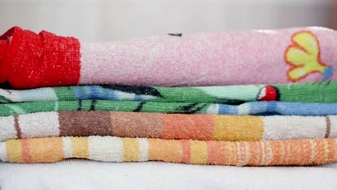 Close-up of hands putting stack of fresh bath towels on a shelf Stock Footage 170703696