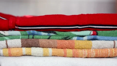 Close-up of hands putting stack of fresh bath towels on a shelf Stock Footage 171105792