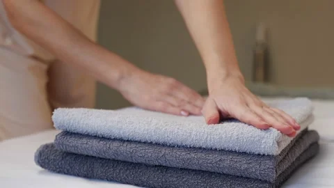Close-up of hands putting a stack of fresh bath towels on a sheet. Room service Stock Footage 233281874