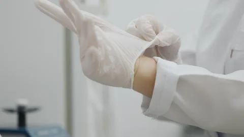 Close-up of the hands putting on white protective gloves. Stock Footage 294158323