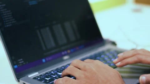 Close-up of hands rapidly typing on a laptop keyboard, displaying lines of .. Stock Footage 341353859