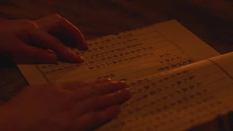 Close-up of Hands Reading Ancient Chinese Textbook at Night Video stock 336548154