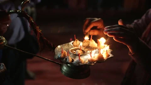 Close up of hands receiving blessings over sacred Aarti flames on brass tray Stock Footage 341325196