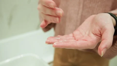 Close-up hands receiving clear liquid soap over bathroom sink while rubbing Stock Footage 345657571