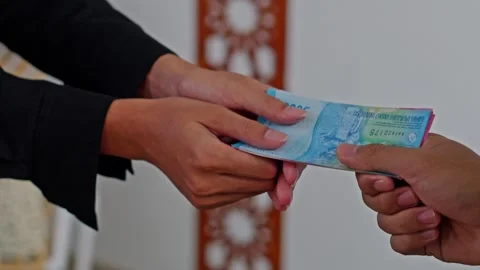 Close-up of Hands receiving zakat Al-Fitr with cash money at mosque Stock Footage 329103231