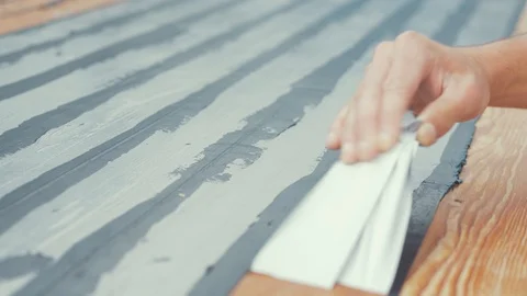 Close up hands removing masking tape from boat roof douglas fir planking. Stock Footage 108571254