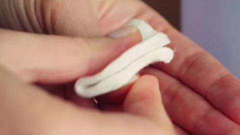 Close-up of hands removing nail polish with a cotton pad and nail polish remover Stock-Footage 336179600