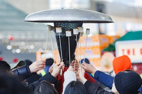Close-up of hands roasting marshmallows over fire in a Christmas atmosphere Stock Photos