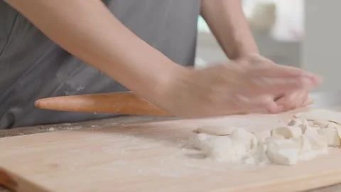 Close-up of Hands Rolling Dough on Wooden Board in Kitchen 動画素材 336529518
