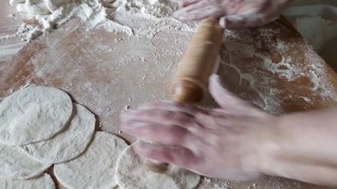 Close-up hands rolling out dough with a wooden rolling pin Stock Footage 275146509
