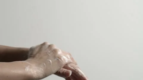 Close-up of Hands Rubbing Soap Suds Together on Grey Background 库存影片 334647397