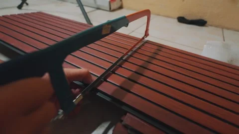 Close-up of Hands Sawing Composite Decking Panel with a Hacksaw for Home Stock Footage 333321785