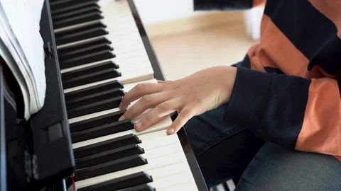 Close-up of hands of school boy playing piano in living room. Child having fun Stock Footage 252428014