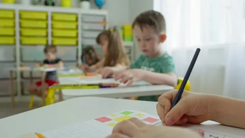 A close-up of the hands of a schoolboy drawing in a notebook. Stock Footage 245943647