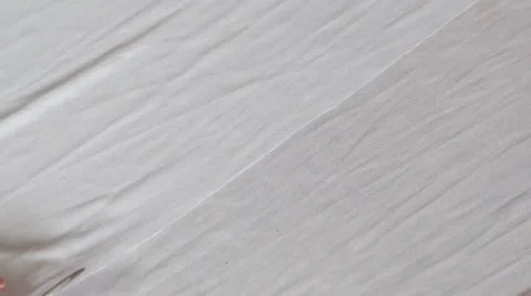 Close up of hands with scissors cutting white material Stock Footage 67613745