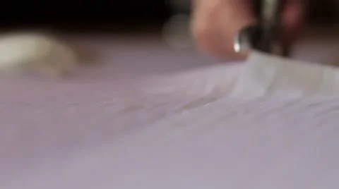 Close up of hands with scissors cutting white material Stock-Footage 67613755