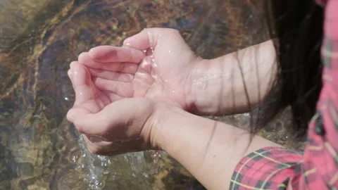 Close-up of hands scooping fresh streams in a forest river. Slow motion. Stock Footage 170588992