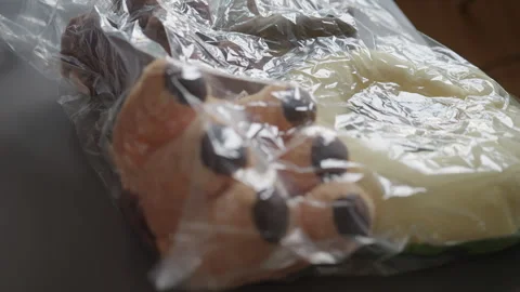 Close-up of hands sealing clear plastic vacuum bag containing various stuffed Stock Footage 319772769