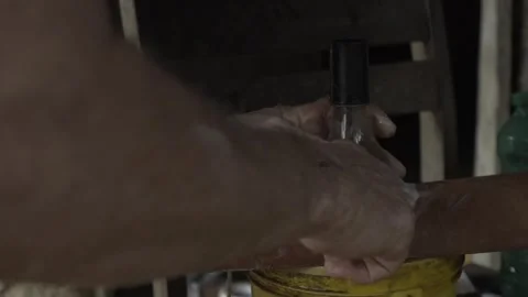 Close-up of Hands Sealing Solar Bottle Light on Roof Tile with Caulk, Conde Stock Footage 320571220