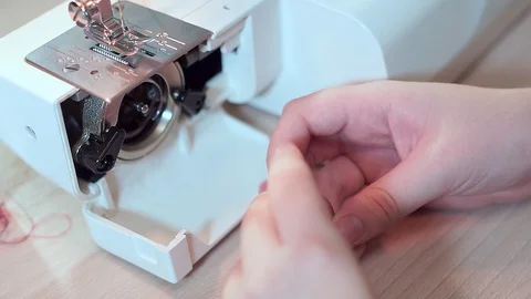 Close-up, hands of a seamstress are preparing a bobbin for a sewing machine Видео 101870960