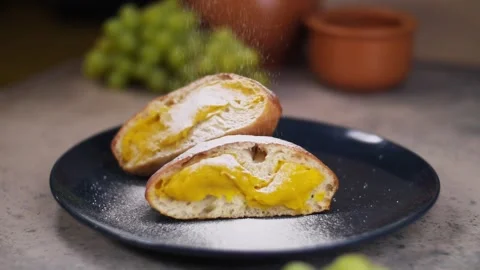 Close-up of hands separating a sweet bun with a creamy filling. Video stock 240756882