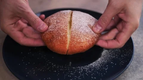 Close-up of hands separating a sweet bun with a creamy filling. Stock-Footage 240757050