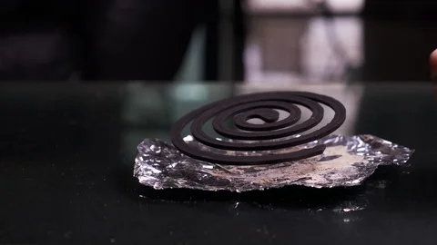 Close-up, hands set fire to black spiral insect repellent mosquito, coil incense Stock-Footage 99489654