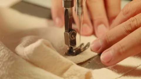 Close Up of Hands Sewing Fabric with an Industrial Sewing Machine Stock Footage 341907149
