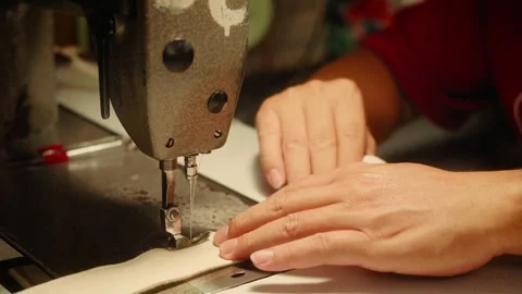 Close Up of Hands Sewing Fabric with an Industrial Sewing Machine Stock Footage 341907201