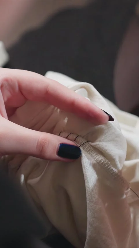Close up hands sewing white fabric with black nails detailed needle and thread Stock Footage 346794772