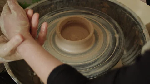 Close-up of hands shaping clay on a pottery wheel. Ceramic crafting and pottery Stock Footage 303515146