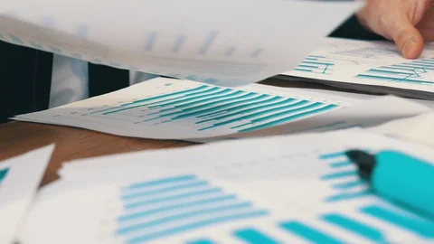 Close-up of hands shifting stack of papers with financial charts Stock Footage 121703125
