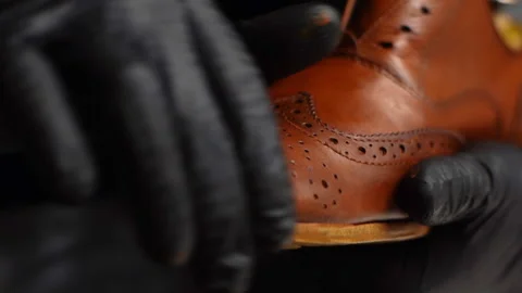 Close-up hands of shoemaker in black gloves applying paint on toe cup of light Vídeos de archivo 150011494
