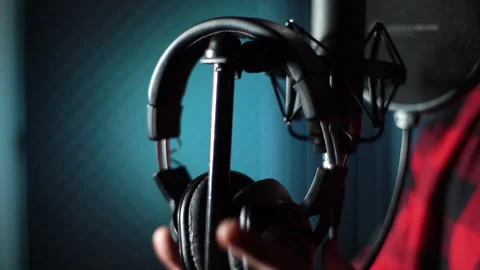 Close-up hands of singer taking off headphones of rack for microphone at music Stock Footage 147879685