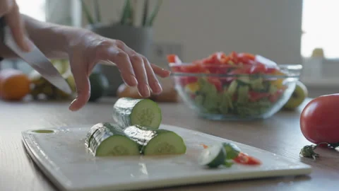 Close-Up Hands Slicing Crisp Cucumber On Board With Fresh Salad Bowl Stock Footage 308454012