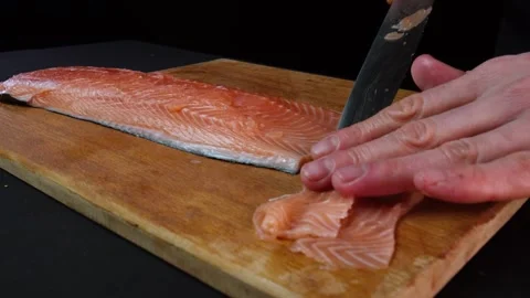 Close up hands slicing fish in slow motion in a dark kitchen Video stock 153206946