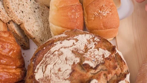 Close Up of Hands Slicing Fresh Baguette Amidst Bread Assortment Stock Footage 337768641
