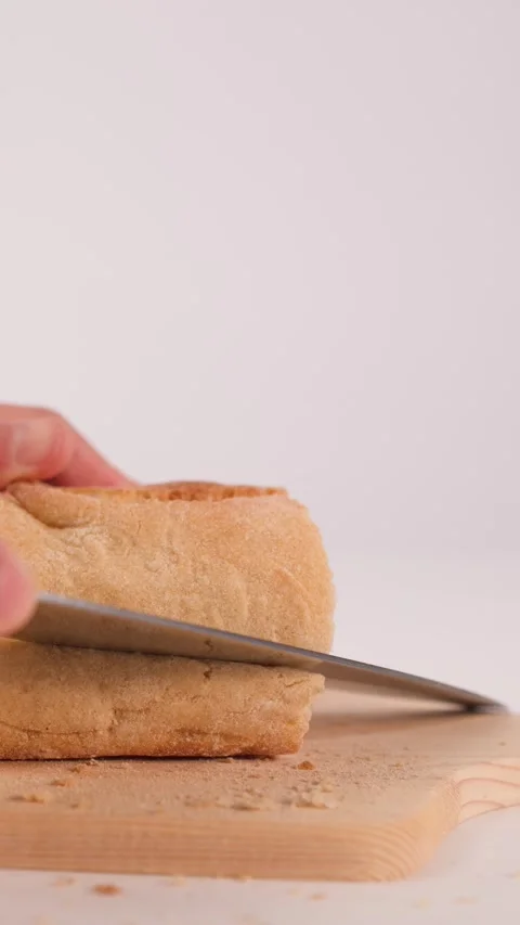 Close Up of Hands Slicing Fresh Bread on Wooden Board Stock Footage 337691022