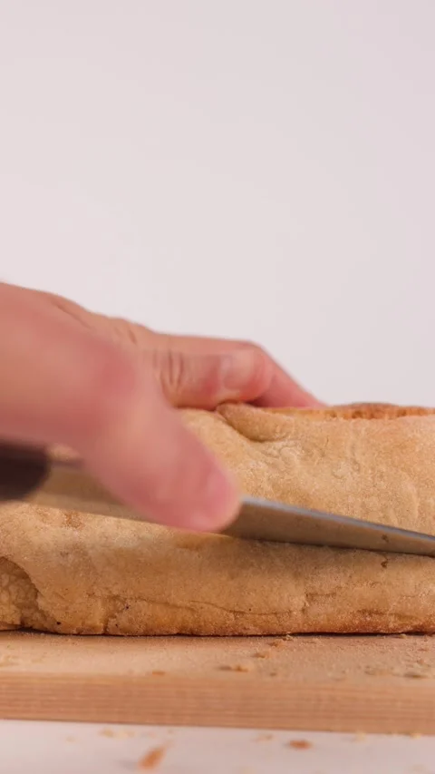 Close Up of Hands Slicing Fresh Crusty Bread on Wooden Board Stock Footage 337518945