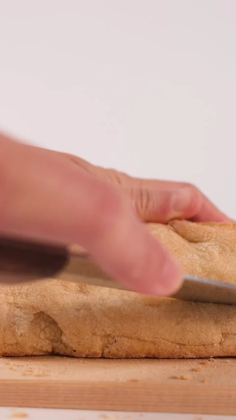 Close Up of Hands Slicing Fresh Crusty Bread on Wooden Board Stock Footage 337689641