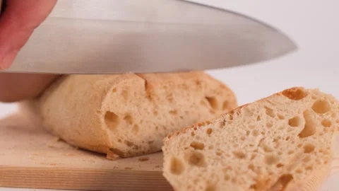 Close Up of Hands Slicing Fresh Crusty Bread on Wooden Board Stock Footage 337690995