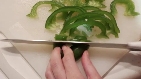 Close-Up of Hands Slicing Fresh Green Peppers in a Quiet Home Kitchen Video stock 328867265