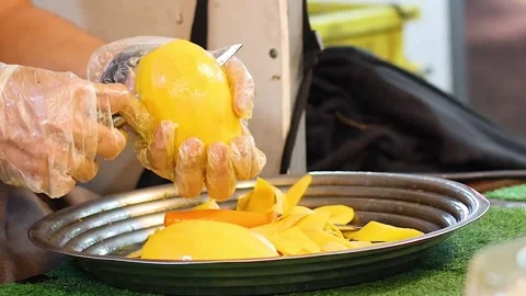 Close Up of Hands Slicing Fresh Mango into a Metal Tray 库存影片 326847424